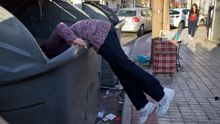 Una mujer, buscando en el interior de un contenedor en Sevilla