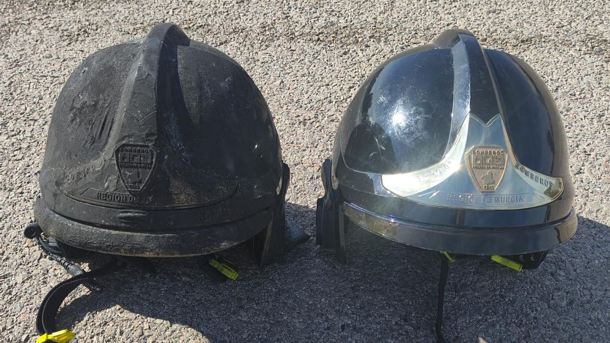 Estado en que ha quedado el casco de uno de los bomberos que ha extinguido el fuego en la vivienda de Águilas. Al lado, un casco nuevo. CEDIDA