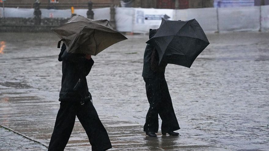 Varias personas intentan sujetar sus paraguas