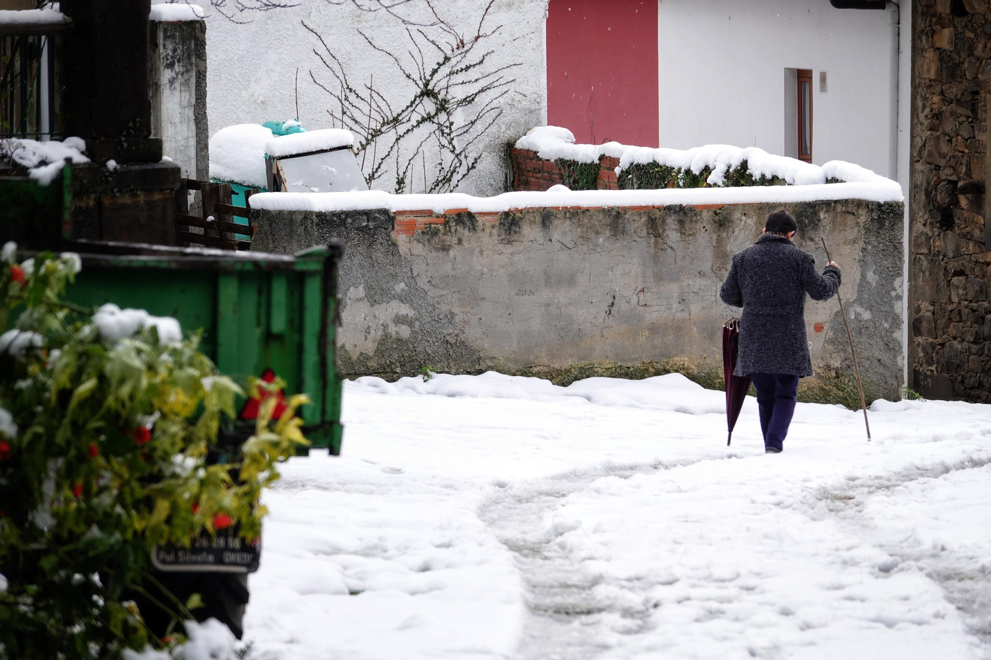 Una mujer camina por la calle cubierta de nieve en Asturias este miércoles