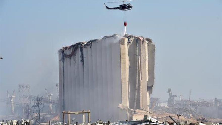 Un helicóptero participa en las labores de extinción de los incendios que todavía permanecen activos tras la gran explosión registrada el martes en Beirut.