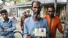 A. Karim, habitante del enclave indio en Bangladesh de Dashiar Chhara, muestra, el 18 de mayo de 2015, un viejo documento de identidad emitido por las autoridades indias