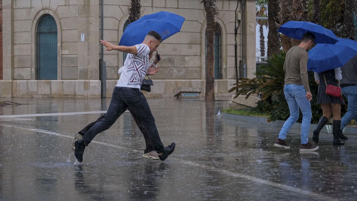 Una persona se protege de la intensa lluvia en Alicante, en una foto de archivo