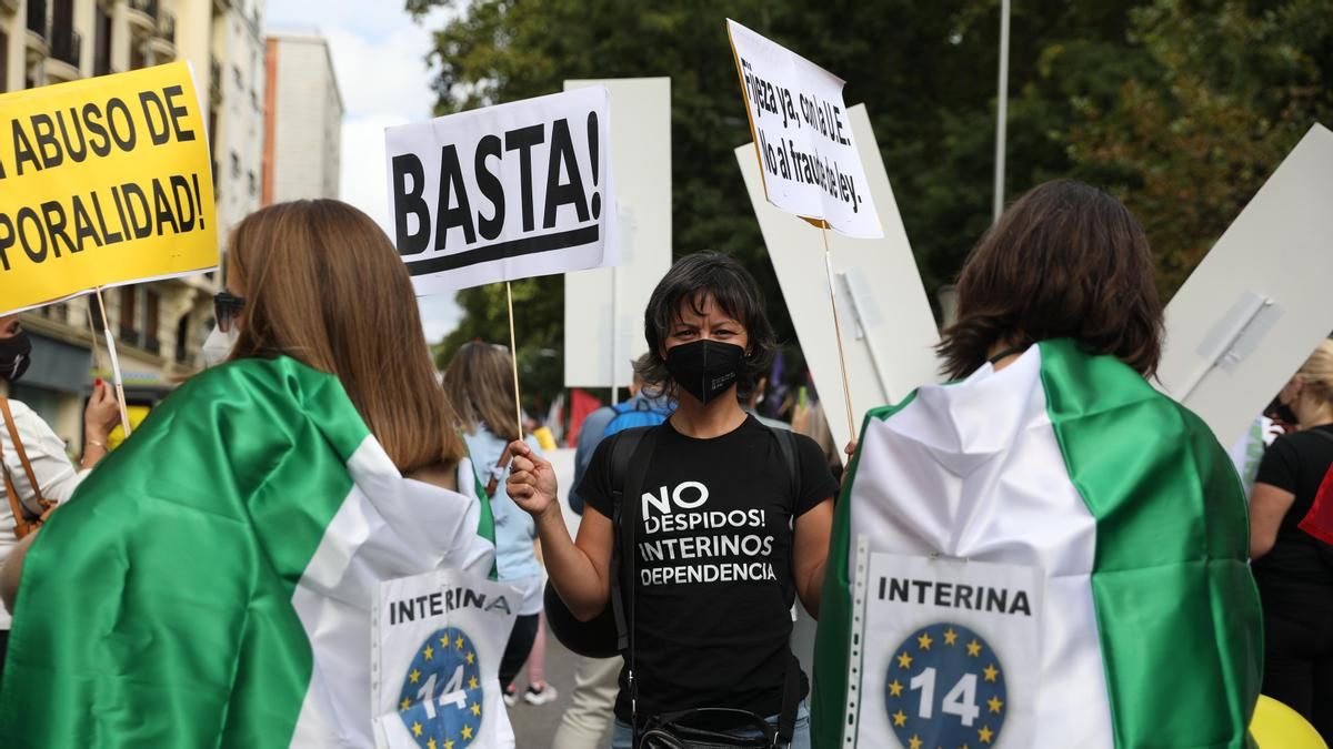 Una mujer sostiene una pancarta donde se lee "¡Basta!", en una manifestación de trabajadores interinos para que sean declarados empleados fijos.