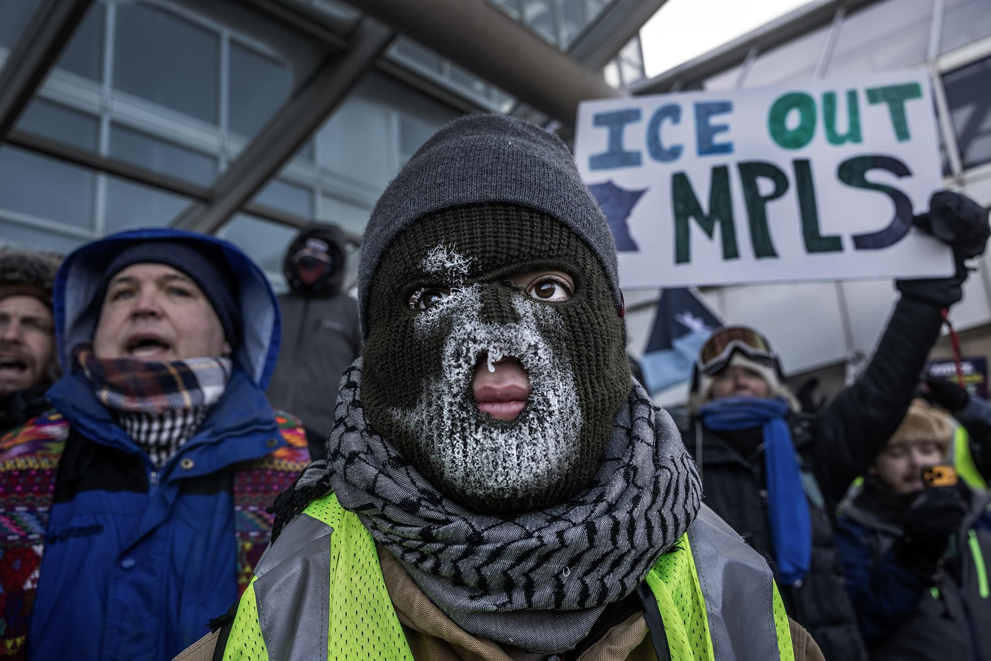 El hielo aparece sobre la máscara de un manifestante mientras un grupo de personas se concentra, bajo temperaturas de hasta -30 °C, frente al Aeropuerto Internacional de Minneapolis-Saint Paul para mostrar su oposición a las operaciones migratorias en el estado. 23 de enero de 2026. © David Guttenfelder / The New York Times.