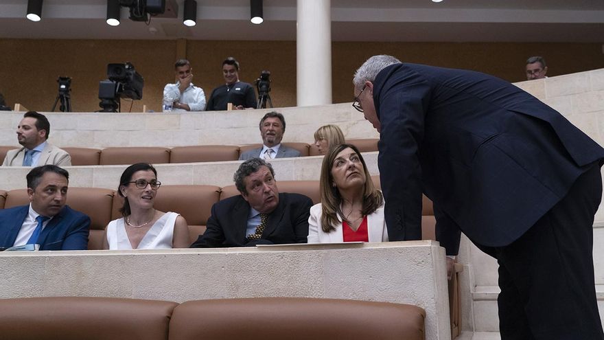 Hernando conversa con la presidente de Cantabria antes de un pleno.