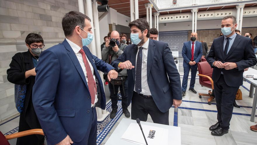 El presidente de la Comunidad de Murcia, Fernando López Miras (c), saluda al portavoz de Vox en el parlamento murciano Juan José Liarte (i) en presencia del portavoz del Partido Popular Joaquín Segado (d). EFE/Marcial Guillén