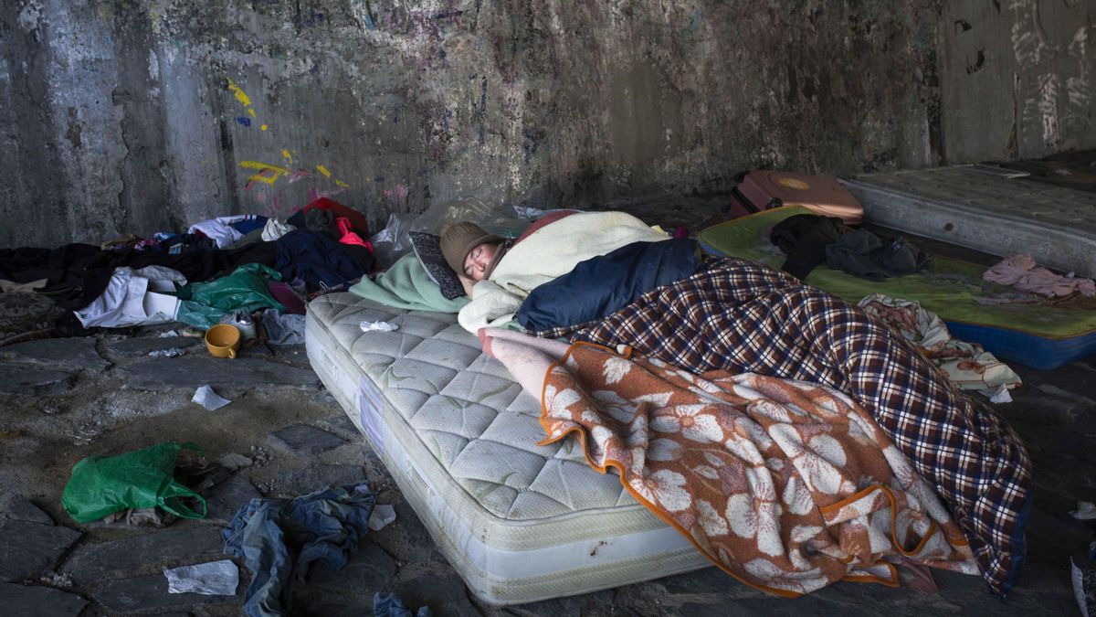 Una persona duerme al raso junto a la M-30.