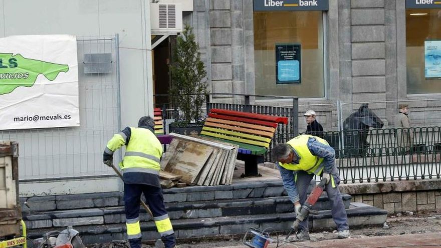 El Ayuntamiento de Oviedo ha iniciado este lunes la retirada de los bancos arcoíris de la plaza de la Escandalera dentro de la reforma de la zona para mejorar su accesibilidad y eliminar las barreras arquitectónicas.