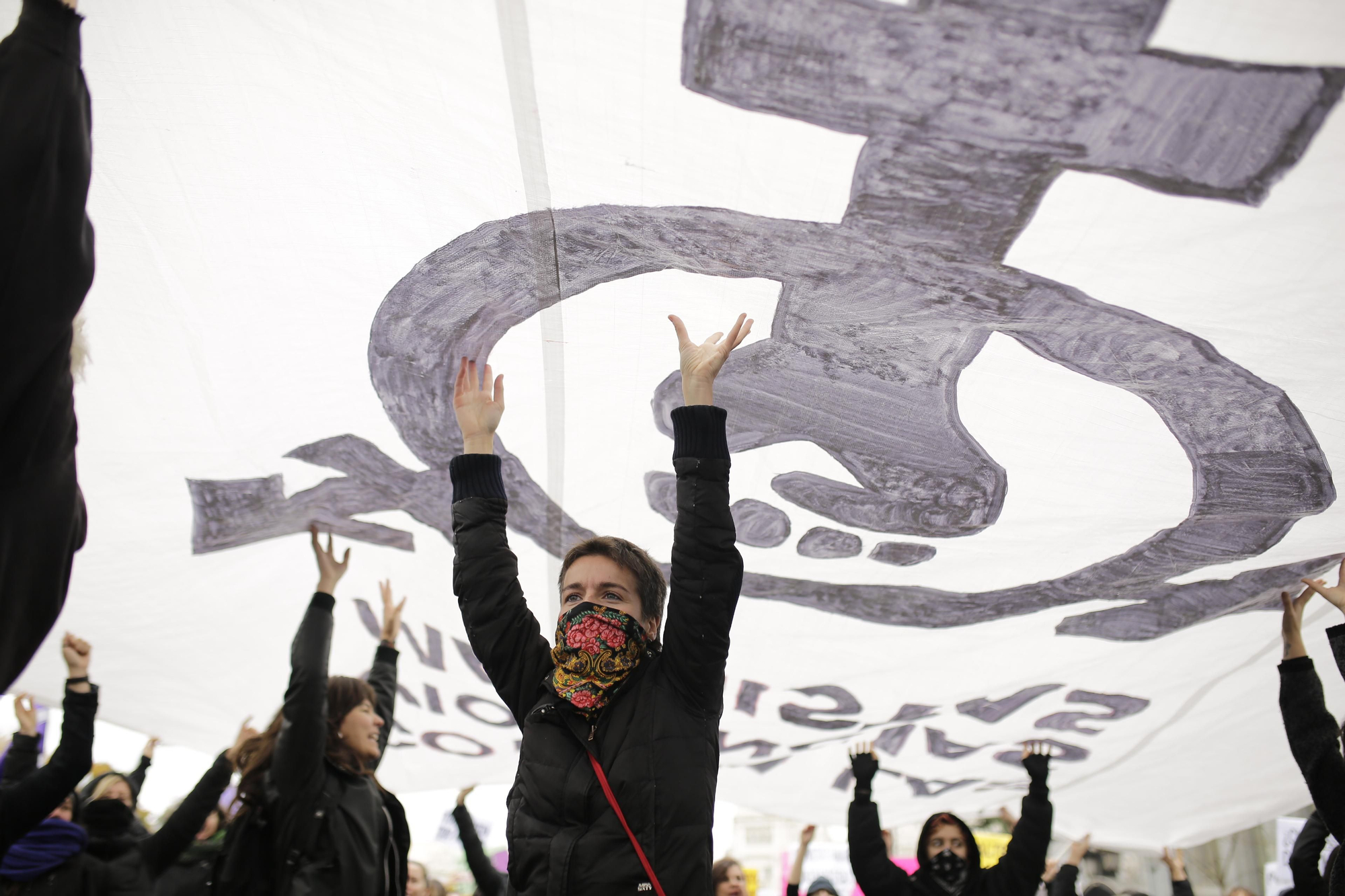 Manifestantes portan una gran pancarta feminista durante el 25N
