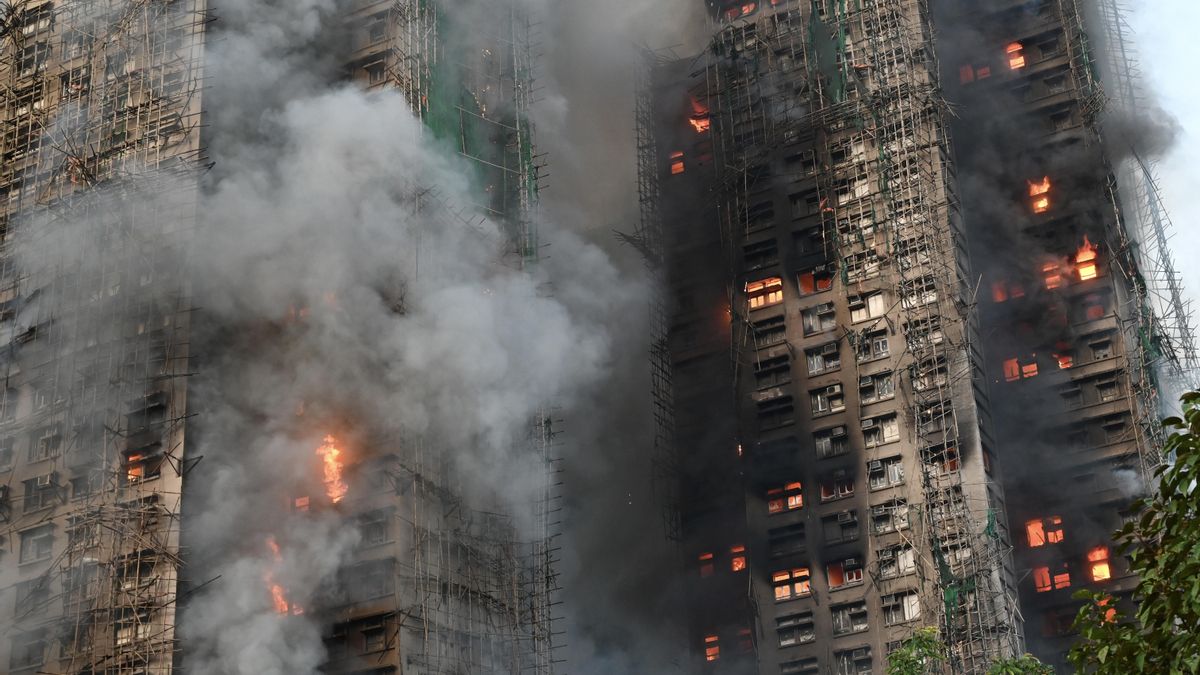 Vista de cerca del gran incendio que se desató en una urbanización de rascacielos Hong Kong. Se pueden apreciar los andamios de bambú en la fachada de dos de los edificios en llamas.