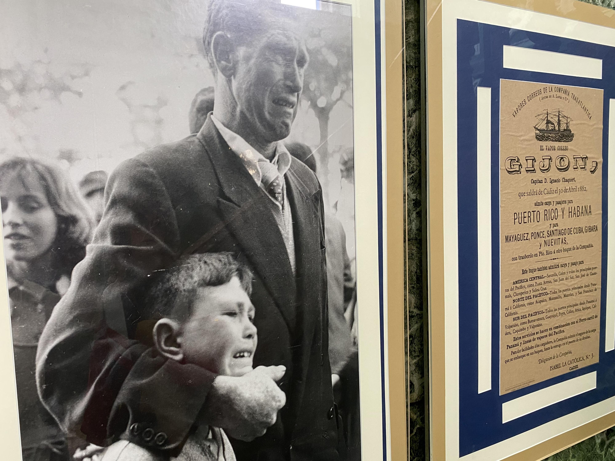 Imagen del Museo de la Emigración de Colombres, con la foto -obra de Manuel Ferrol- del niño Juan Jesús Calo y su padre, en 1957, en el puerto de A Coruña, mientras veían partir un barco rumbo a Argentina, junto a un cartel de un vapor para emigrantes españoles a Puerto Rico y Cuba, con salida desde Cádiz el 30 de abril de 1812.