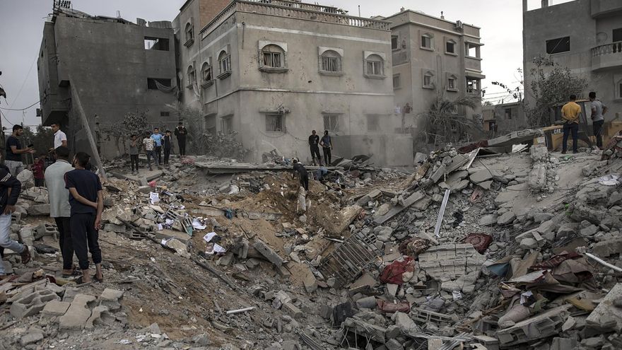 Palestinos buscan cadáveres y supervivientes entre los escombros de un edificio residencial tras un ataque israelí en Jan Yunis, en el sur de la Franja de Gaza, el 12 de noviembre de 2023.