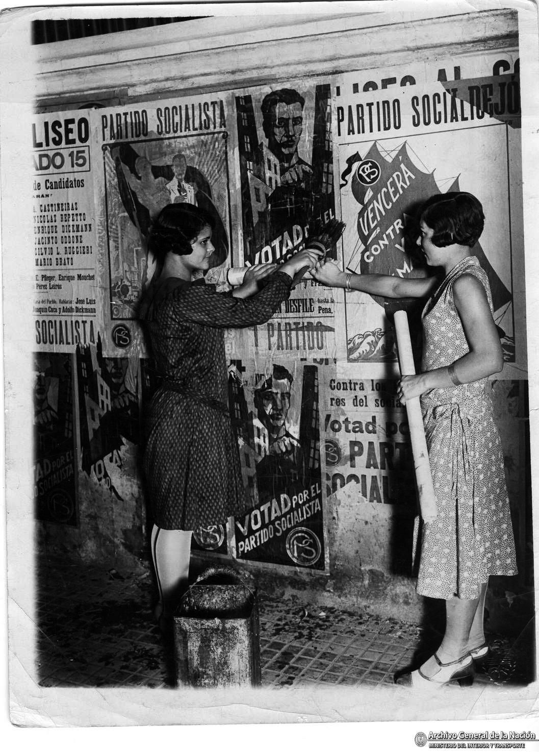 Dos jóvenes socialistas pegan afiches políticos en mayo de 1930.