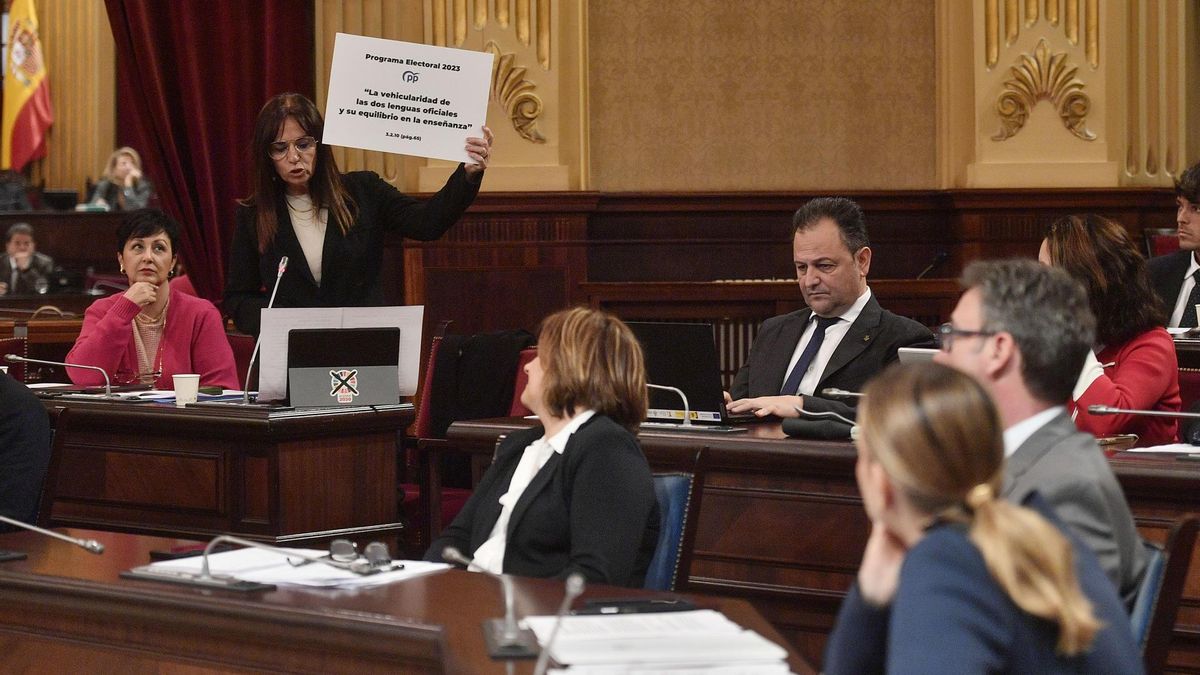La presidenta del Govern balear, Marga Prohens, en primer plano, mientras la portavoz de Vox en el Parlament, Manuela Cañadas, exhibe el acuerdo alcanzado con el PP en materia lingüística a inicios de legislatura