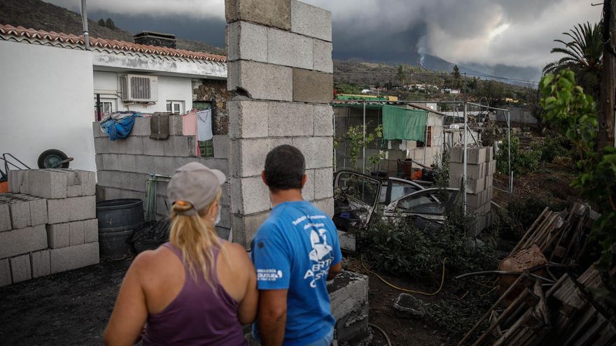 Un hombre y una mujer sacan sus pertenencias de su casa por la actividad del volcán de Cumbre Vieja, en La Palma