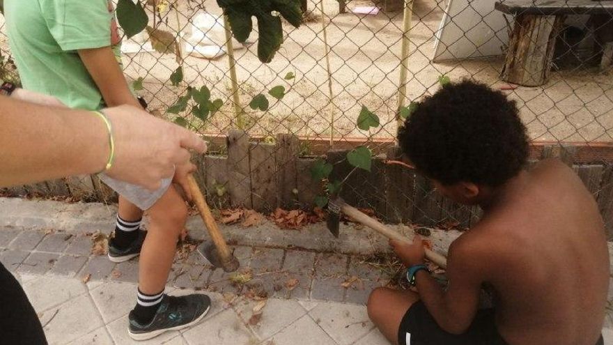 Niños limpiando la acera de cacas
