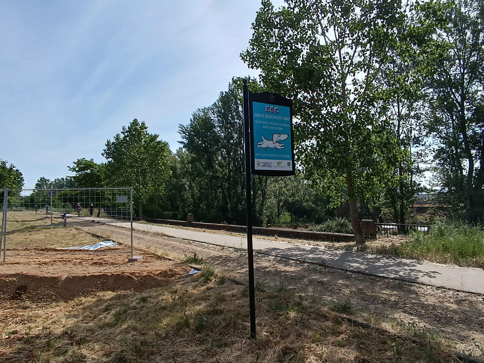 Valla de obra preparada para cortar la senda de La Lastra junto a la zona de talado masivo para construir una pasarela en el río Torío.