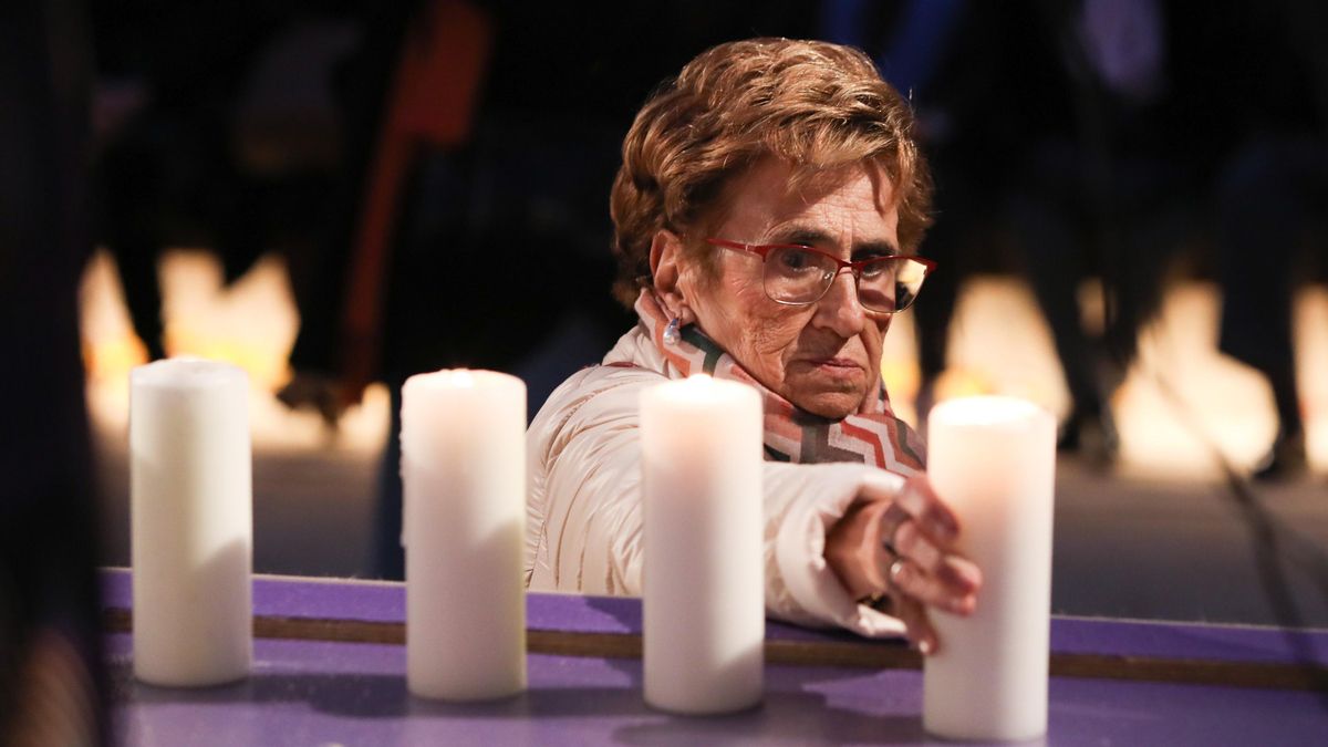 Una mujer pone una vela para recordar a las víctimas de violencias contra la mujer en Toledo
