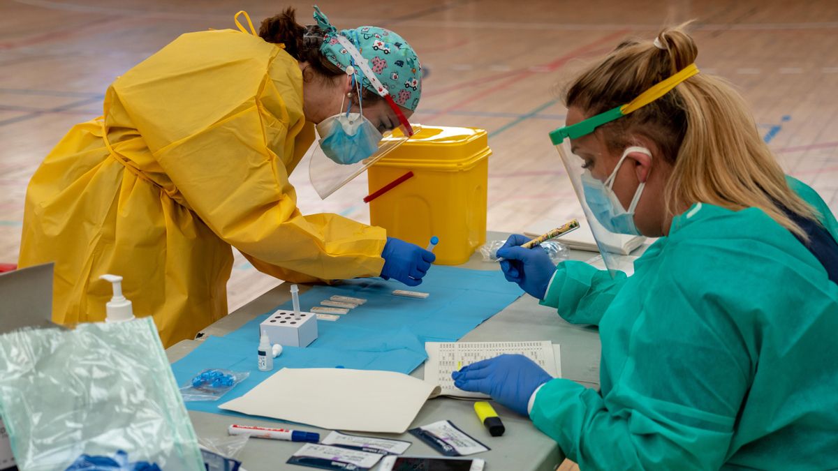 Sanitarios trabajando durante las pruebas de cribado de covid-19 con test de antígenos en el pabellón deportivo de 'El Paraguas'. En Sevilla (Andalucía, España), a 28 de octubre de 2020.