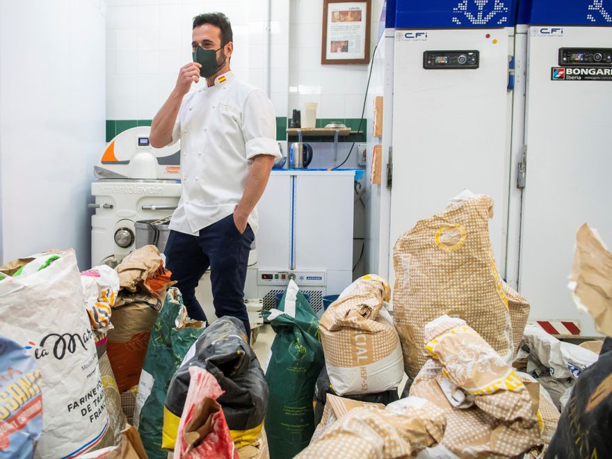 Domi Vélez posa rodeado de sacos de harina en su panadería de la calle Suecia, en la localidad sevillana de Lebrija