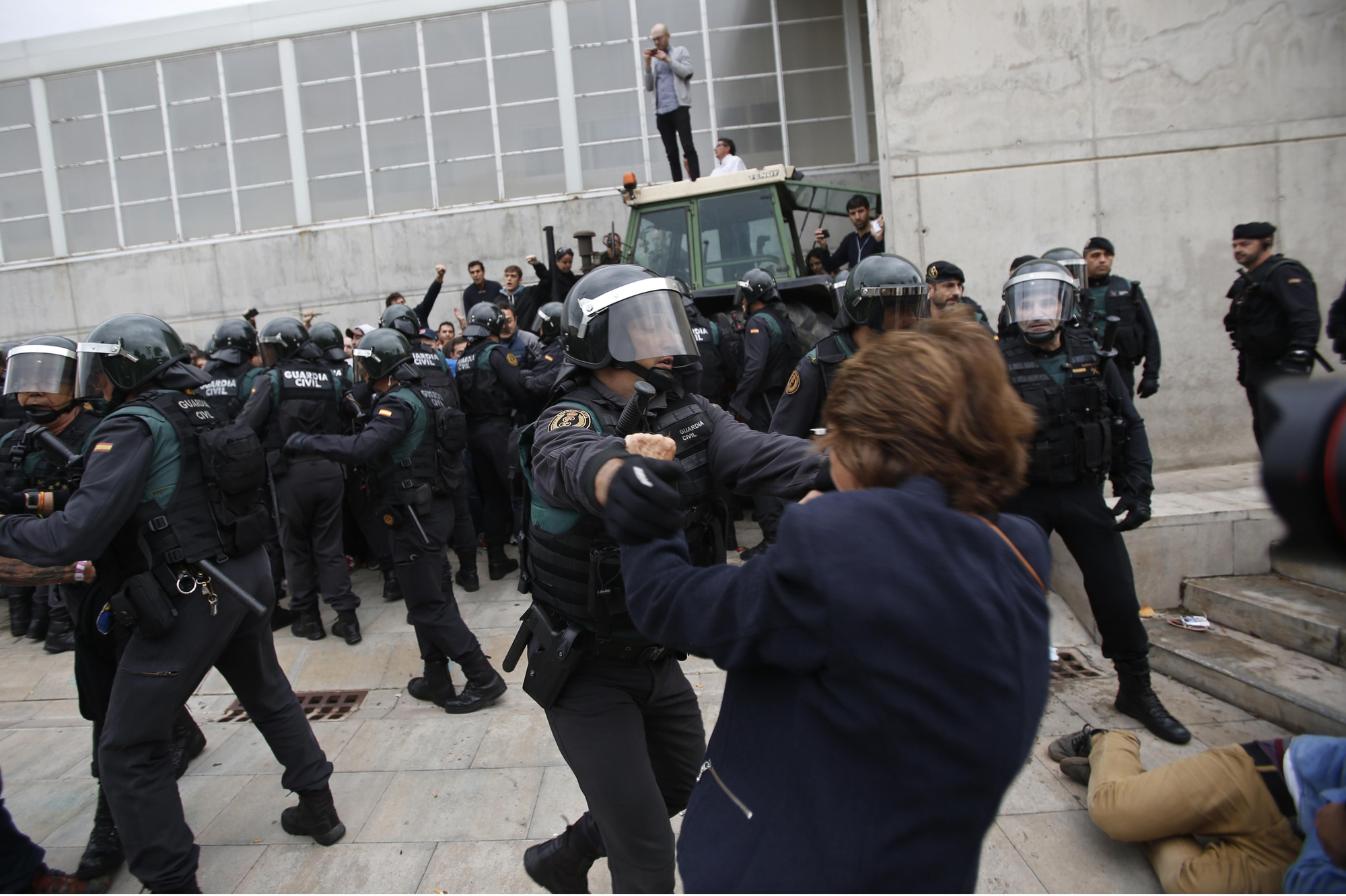 Civil guards clear people away from the entrance of a sports center, assigned to be a polling station by the Catalan government in Sant Julia de Ramis, near Girona, Spain, Sunday, Oct. 1, 2017. Scuffles have erupted as voters protested as dozens of anti-rioting police broke into a polling station where the regional leader was expected to show up for voting on Sunday.
