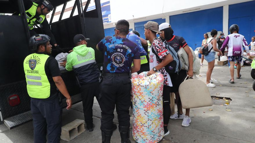Personas hablan con policías este sábado cerca a edificios afectados por los terremotos ocurridos en la zona de Caraballeda, en La Guaira.