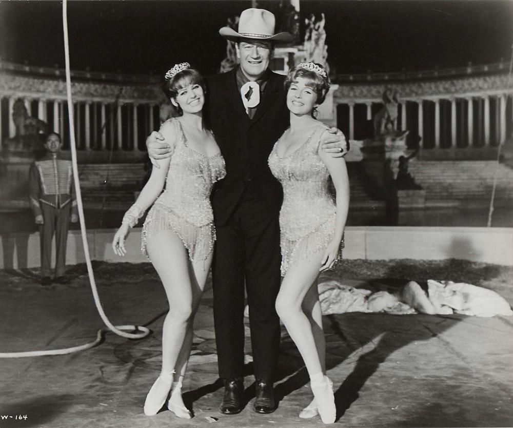 Cardinale, John Wayne y Rita Hayworth, con el monumento a Alfonso XII al fondo durante el rodaje de su película en Madrid