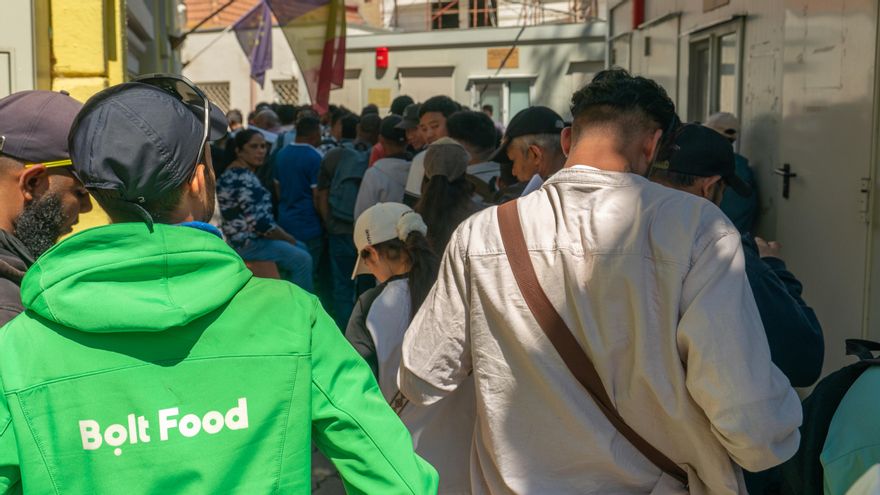 Personas migrantes hacen fila frente a una de las oficinas de Inmigración del Gobierno de Rumanía.