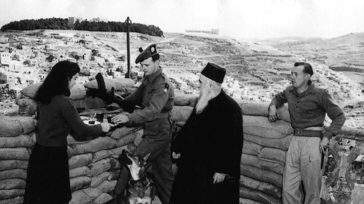 Una joven y un anciano judíos ofrecen un refresco a unos soldados ingleses que han instalado un puesto de vigilancia en la terraza de su casa en Jerusalén, en 1948.