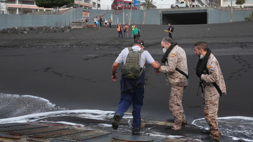 Efectivos de las Fuerzas Armadas ayudan a desembarcar a un agricultor en la playa de Puerto Naos.