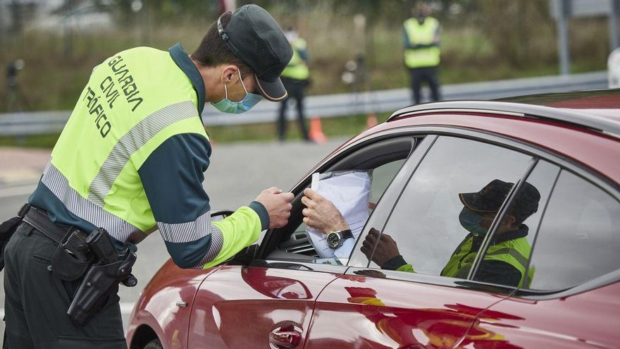 Un agente de la Guardia Civil de Tráfico comprueba la documentación de un conductor en un control policial en la frontera entre Navarra y el País Vasco.