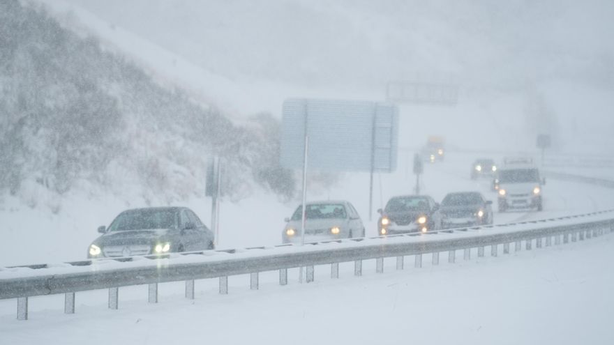 Archivo - Varios coches conducen por una carretera cubierta de nieve en Cantabria.-ARCHIVO