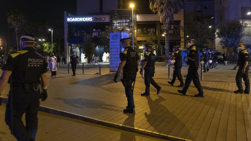 Agentes de la Guardia Urbana forman una línea tras desalojar la playa de la Barceloneta la noche en la que entra en vigor el toque de queda en Cataluña, a 16 de julio de 2021, en Barcelona, Catalunya (España). El Tribunal Superior de Justicia de Cataluña