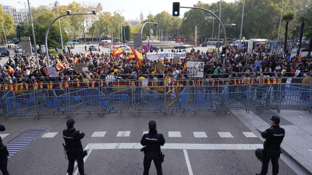 Algunas decenas de personas se congregan en la plaza de Neptuno, próxima al Congreso de los Diputados, en protesta por la investidura de Pedro Sánchez