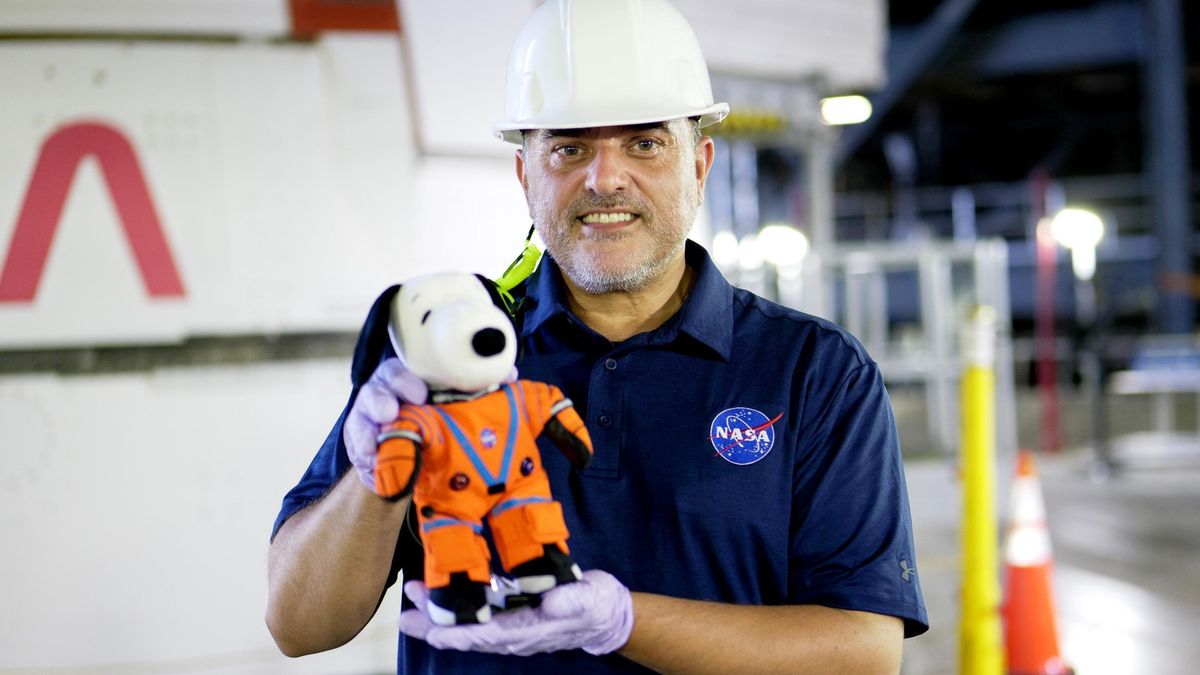 García Llama sostiene el muñeco de Snoopy que viajó a bordo de la nave Orión, una tradición de la NASA.