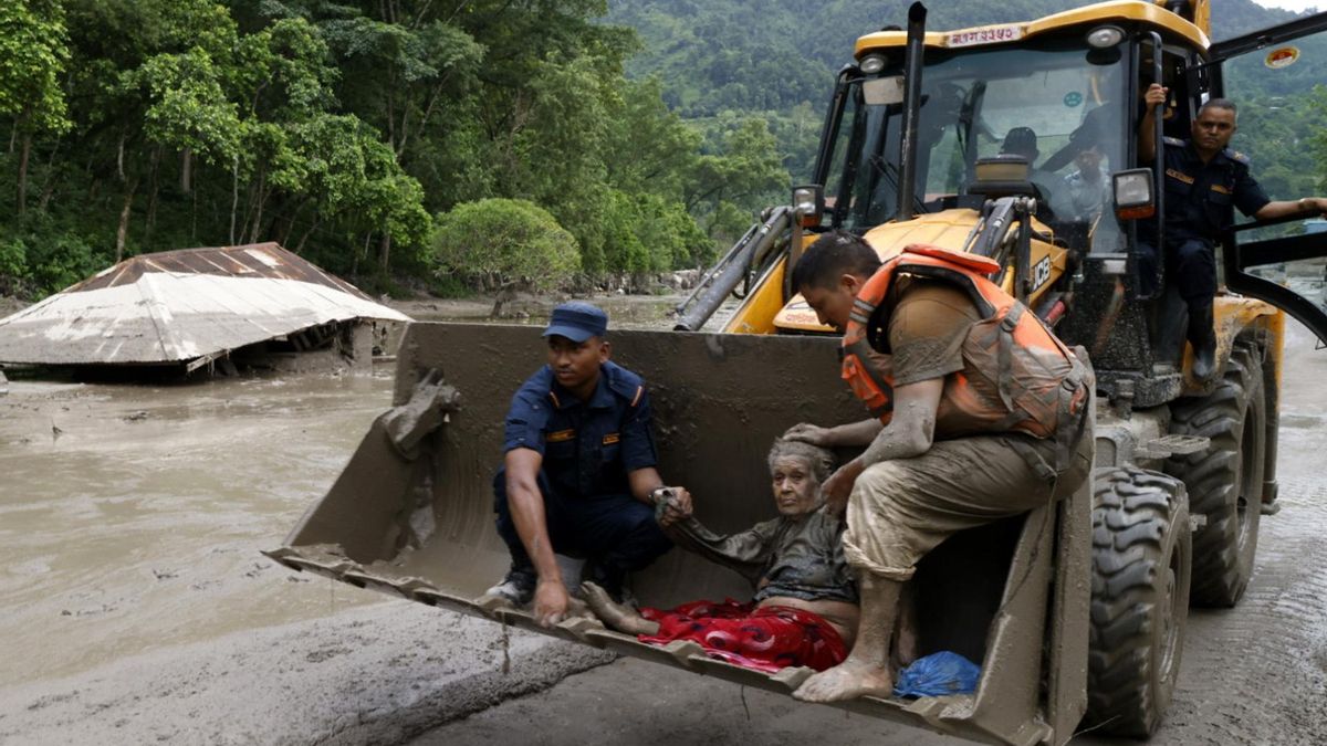 Personal de emergencias trasladan a una anciana rescatada de una residencia de ancianos en Devighat.