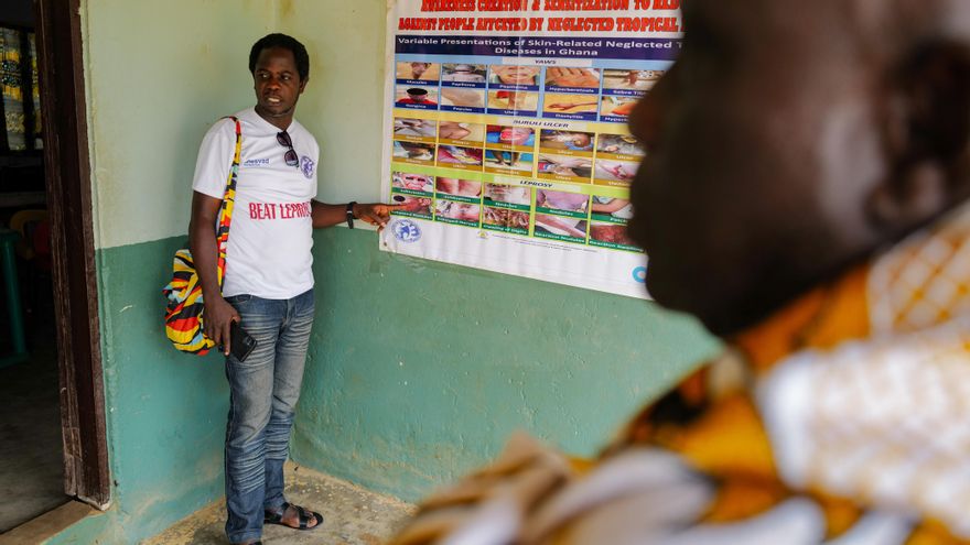 Patrick Davies, de 37 años, un activista por la lucha contra las enfermedades tropicales desatendidas, observa una pancarta de sensibilización en la oficina de la Fundación Gate en Ankarful, Región Central, Ghana.
