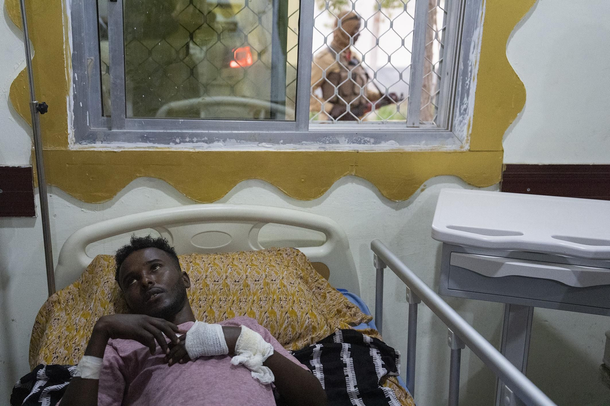 Ahmed Barkhadele Abdullahi, de las Fuerzas de Defensa de Puntlandia, resultó herido en combate. Escucha a su médico mientras otro soldado hace guardia en un hospital de Bosaso, Puntlandia, Somalia, el 28 de enero de 2025.
© Carolyn Van Houten / The Washington Post