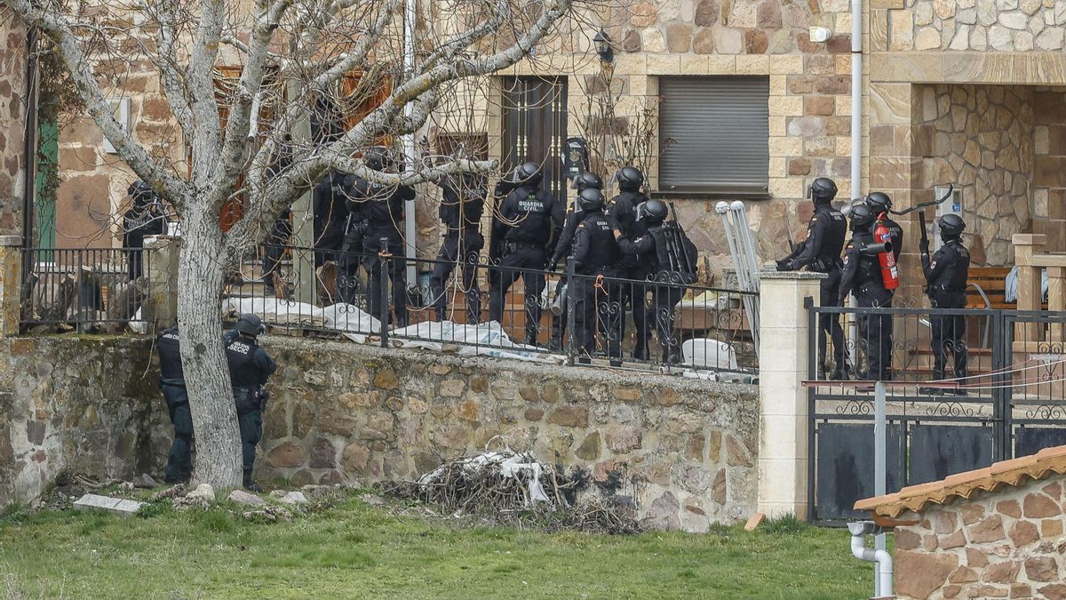 Agentes de la Guardia Civil junto a la vivienda de la pequeña localidad burgalesa de Villoruebo donde un hombre se ha atrincherado tras secuestrar a un taxista en Madrid.
