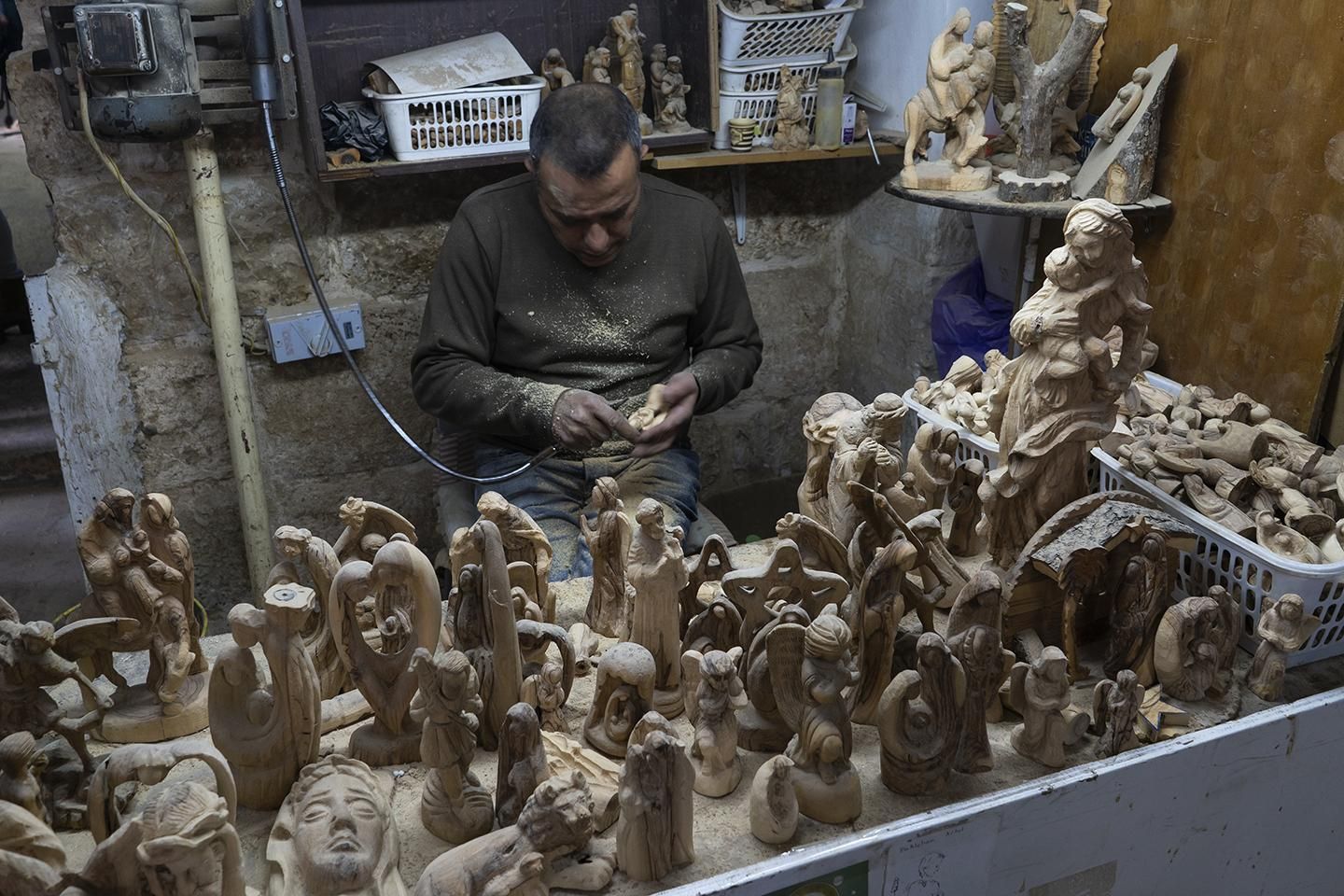 Un artesano talla figuras religiosas en madera de olivo para vendérselas después a los peregrinos en Belén (Palestina). | JOAQUÍN GÓMEZ SASTRE
