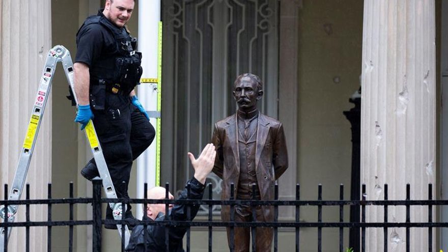 US Secret Service Uniformed Division police use a laser to examine the trajectory of a bullet that was fired through a flagpole, with bullet damage visible on a building column at right, outside the Embassy of Cuba, in Washington, DC, USA, 30 April 2020.