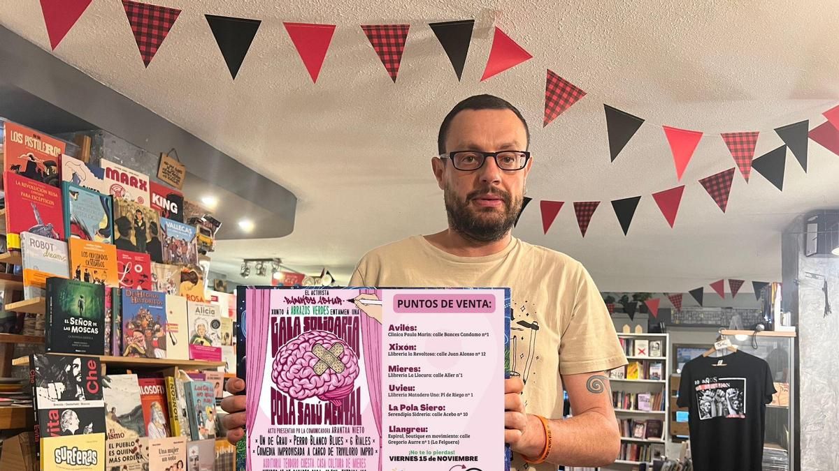 Banksyastur con uno de los carteles con la programación de la gala solidaria.