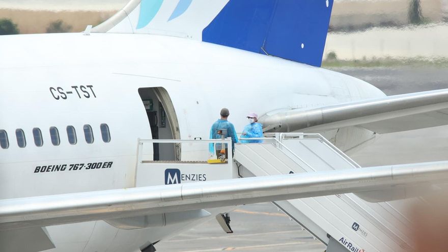 Viajeros de nacionalidad canadiense evacuados del crucero MV Hondius suben a un avión, en el aeropuerto de Tenerife Sur.