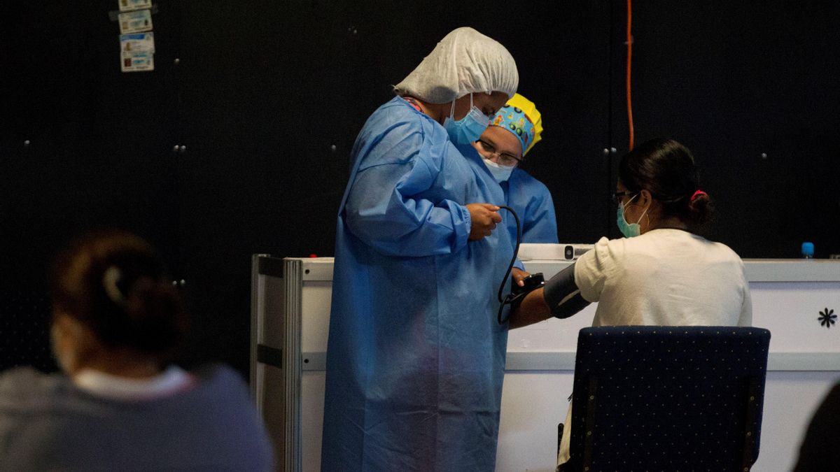 Un miembro del personal de salud atiende a una mujer en un centro para la detección de la nueva variante del coronavirus en Tegucigalpa (Honduras). EFE/ Gustavo Amador/Archivo