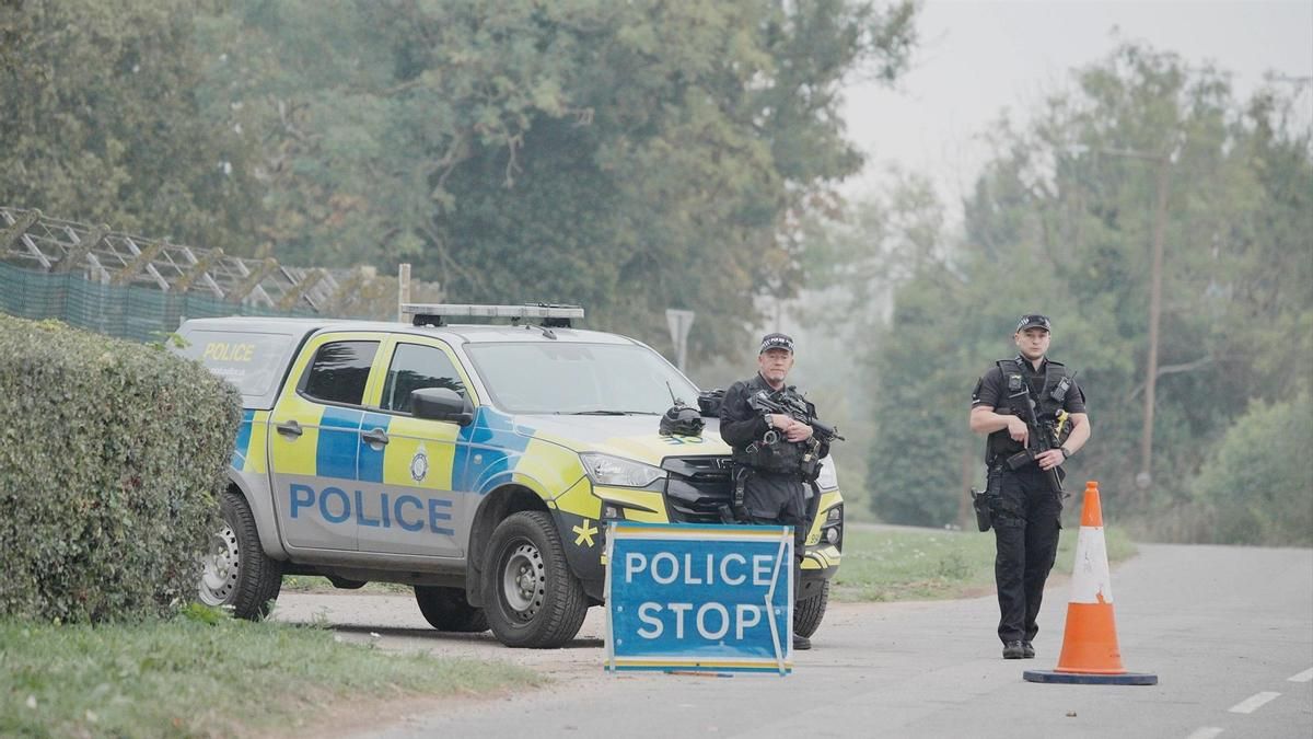 Dos agentes junto a la base militar de Fairford, Inglaterra, este martes.