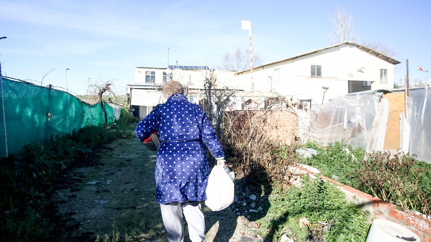 Una mujer camina con bolsas que ha recogido en la entrega de regalos y alimentos organizada por la Fundación Madrina, en la Cañada Real. (Archivo)