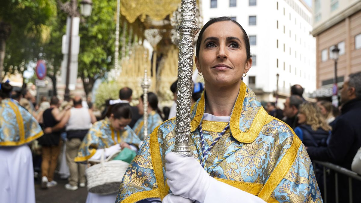 Archivo - Una acólita porta un cirial delante del paso de la Virgen de la Aurora, de la hermandad de la Resurrección de Sevilla, a su paso por la Plaza del Duque, en una foto de archivo.
