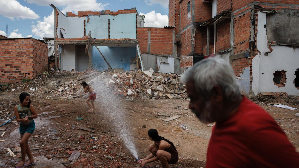 Niños juegan con agua para refrescarse en medio del calor este miércoles, en la Favela do Moinho, en Sao Paulo (Brasil).