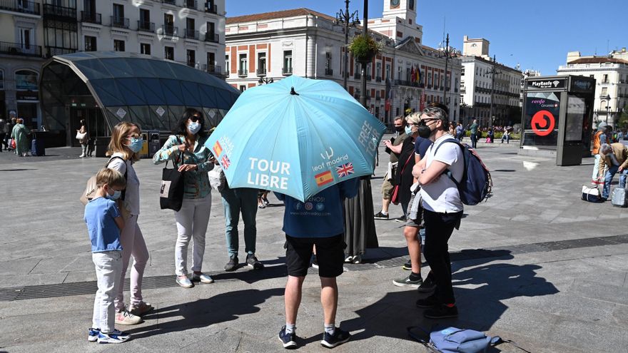 Varios turistas escuchan las explicaciones de un guía en la Puerta del Sol de Madrid. EFE/Fernando Villar